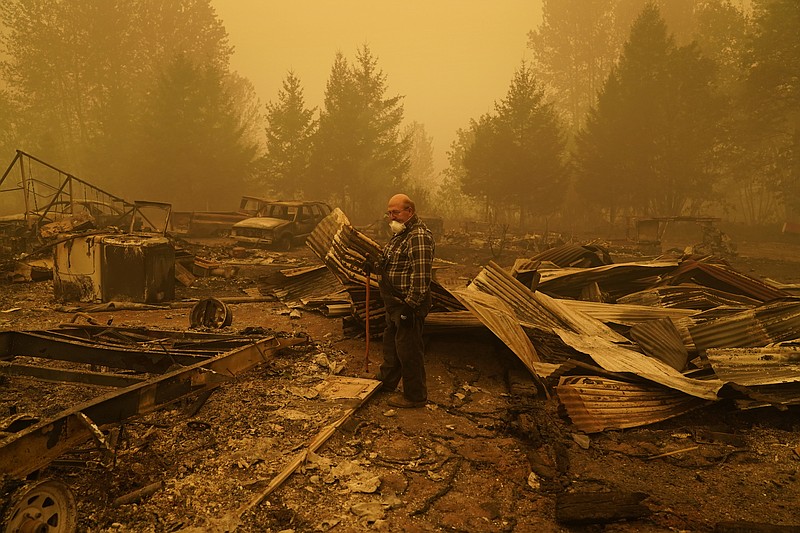 George Coble walks through what remains of a home on his property destroyed by a wildfire Saturday, Sept. 12, 2020, in Mill City, Ore. (AP Photo/John Locher)