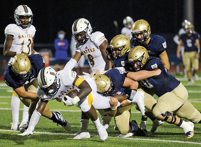 A group of Helias defenders bring down Battle running back Rickie Dunn during Friday night's game at Ray Hentges Stadium.