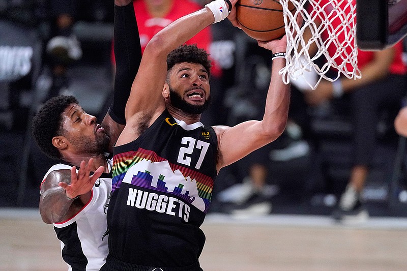 Denver Nuggets' Jamal Murray (27) goes up for a shot as Los Angeles Clippers' Paul George defends during the second half of a conference semifinal playoff basketball game Sunday in Lake Buena Vista, Fla.