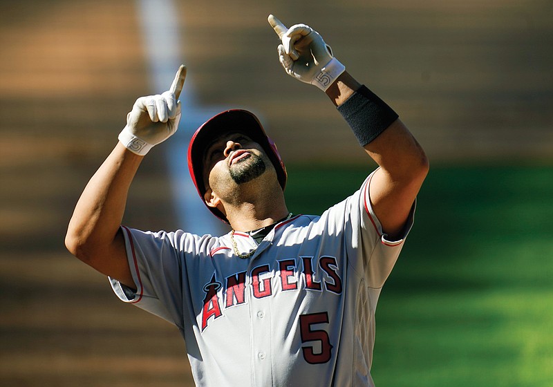 Albert Pujols of the Angels gestures as he crosses home plate after hitting a two-run home run in the eighth inning of Sunday's game against the Rockies in Denver. It was the 660th home run of Pujols' career.