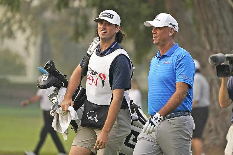 Stewart Cink walks with his caddie and son, Reagan Cink, down the 18th fairway of the Silverado Resort North Course during Sunday's final round of the Safeway Open in Napa, Calif.