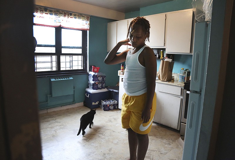 Mason Washington, 11, stands in the kitchen of his family's New York City apartment Aug. 13 after browsing the refrigerator for a mid-morning snack. The family has struggled to keep food in the cupboards during the pandemic: "It was hard feeding them three times a day," said Sharawn Vinson, his mother. 