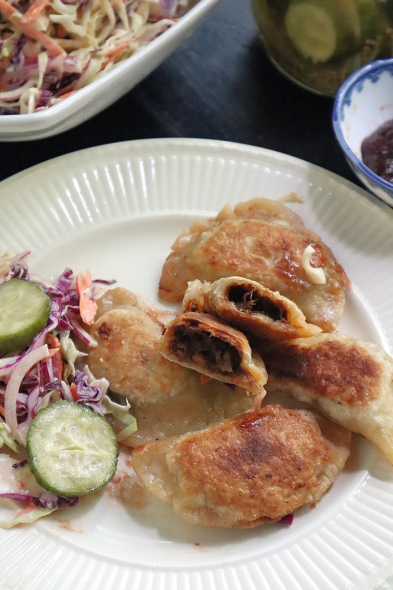 Homemade pierogies stuffed with pulled pork are served with coleslaw and pickles. (Gretchen McKay/Post-Gazette/TNS)