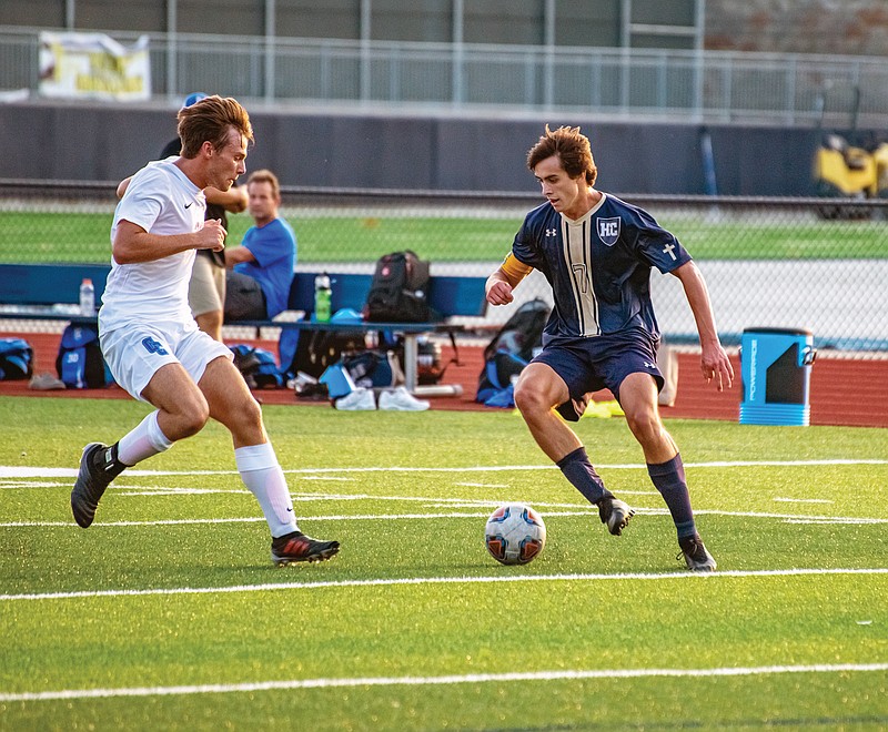 Luke Hynes of Helias dribbles as Carson Harper of Capital City defends during Monday's game at Ray Hentges Stadium.