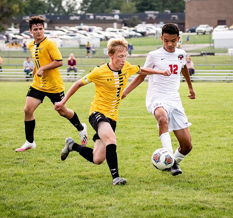 Fulton senior forward Mason Crane (center) tries to gain possession of the ball against Marshall sophomore Erick Salmeron during the Hornets' 5-1 NCMC win over the Owls on Tuesday night at the high school athletic complex. Fulton freshman midfielder Jayden Ayers follows up on the play.
