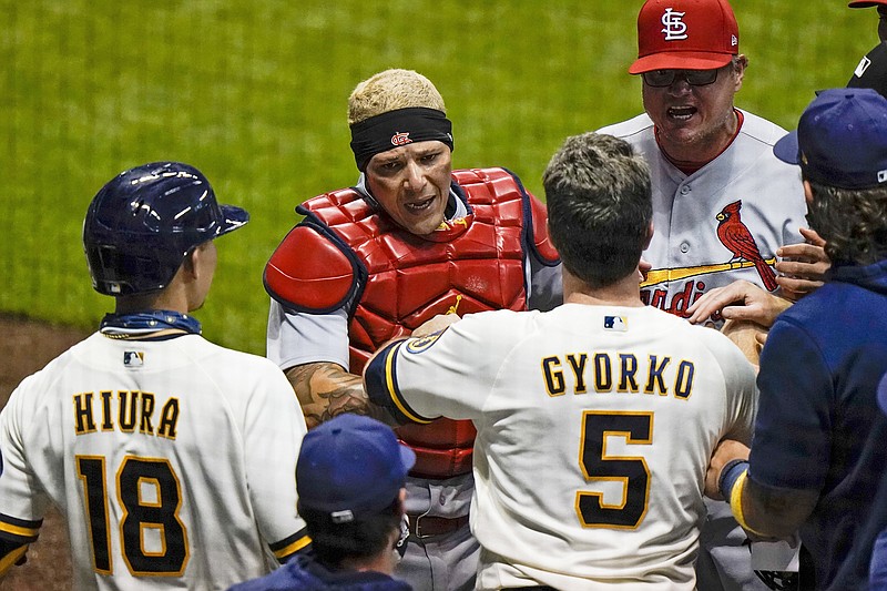 Cardinals catcher Yadier Molina has words with the Brewers' Keston Hiura and Jedd Gyorko during the fifth inning of Tuesday night's game in Milwaukee.