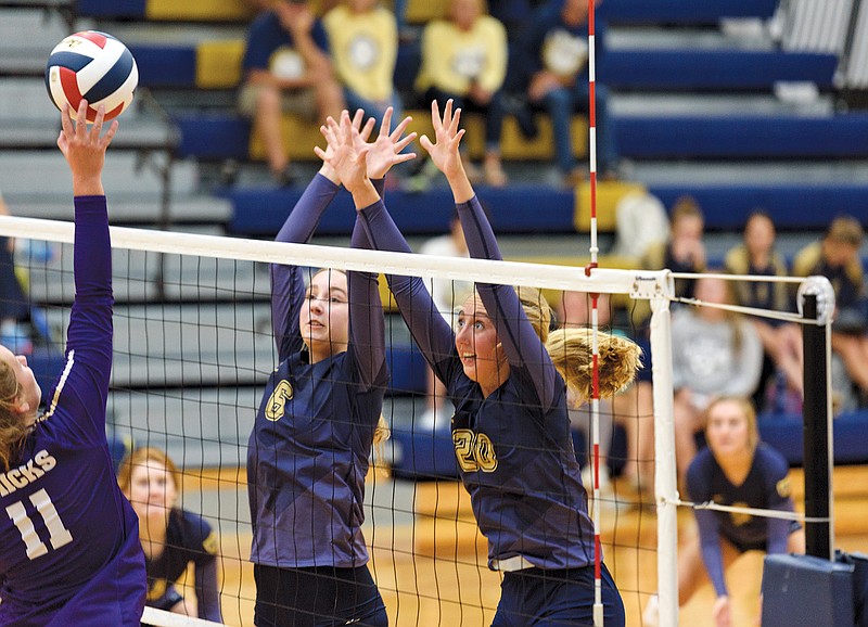 Helias hitters Sydney Mingucci (6) and Jacie Buschjost (20) attempt to block a hit by Pleasant Hill outside hitter Maddy Nelson in the third set of Tuesday's match at Rackers Fieldhouse.