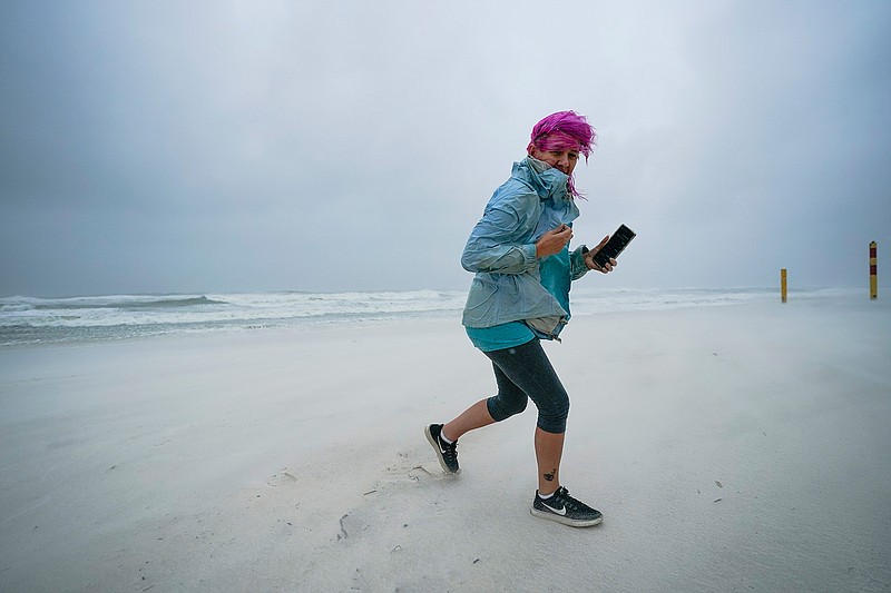 Courtney Watts, of Tuscaloosa, Ala., moves off the beach at Gulf State Park, Tuesday, Sept. 15, 2020, in Gulf Shores, Ala. Hurricane Sally is crawling toward the northern Gulf Coast at just 2 mph, a pace that's enabling the storm to gather huge amounts of water to eventually dump on land. (AP Photo/Gerald Herbrt)