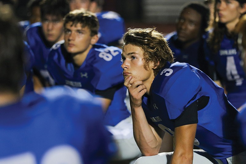 Capital City's Dallas Hardy kneels with the rest of the team and listens to coach Shannon Jolley deliver remarks following a Week 1 game against Warrensburg at Adkins Stadium.