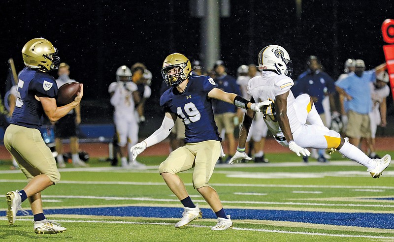 Helias defensive back Aleck Barchenski (19) grins as teammate Alex Clement pulls down an interception on a pass intended for Battle's Manny Chiteri during last Friday's game at Ray Hentges Stadium.