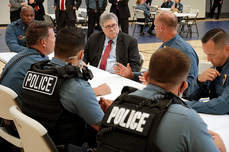 FILE - In this Aug. 19, 2020, photo Attorney General William Barr participates in a roll call with police officers from the Kansas City Police Department in Kansas City, Mo. In a private conference call this week with his U.S. attorneys nationwide, Attorney General William Barr said he wanted prosecutors to be aggressive in charging demonstrators who cause violence. (AP Photo/Mike Balsamo, File)