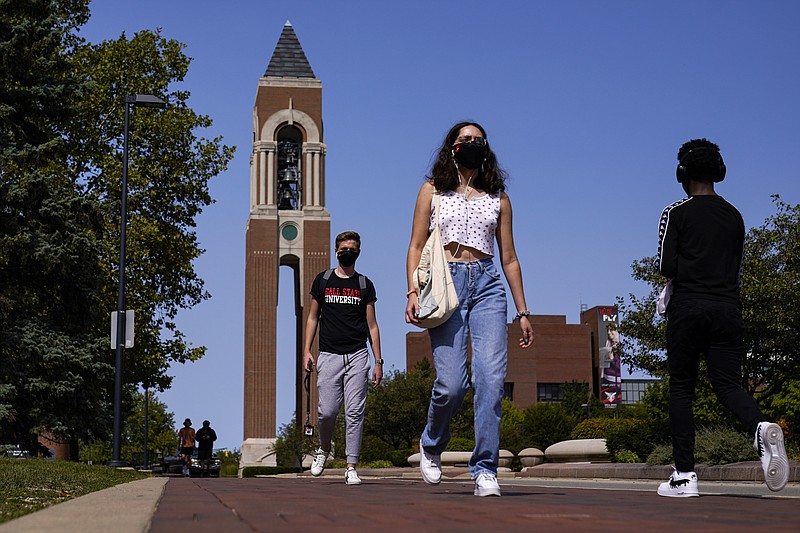 Masked students walk through the campus of Ball State University in Muncie, Ind., Thursday, Sept. 10, 2020. College towns across the U.S. have emerged as coronavirus hot spots in recent weeks as schools struggle to contain the virus. Out of nearly 600 students tested for the virus at Ball State, more than half have returned been found positive, according to data reported by the school. Dozens of infections have been blamed on off-campus parties, prompting university officials to admonish students.  (AP Photo/Michael Conroy)