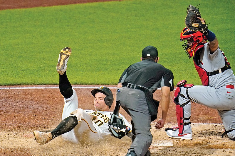 Cardinals catcher Yadier Molina raises his glove after tagging out Bryan Reynolds of the Pirates as umpire Robert Ortiz prepares to make the call during the sixth inning of Thursday night's game in Pittsburgh.