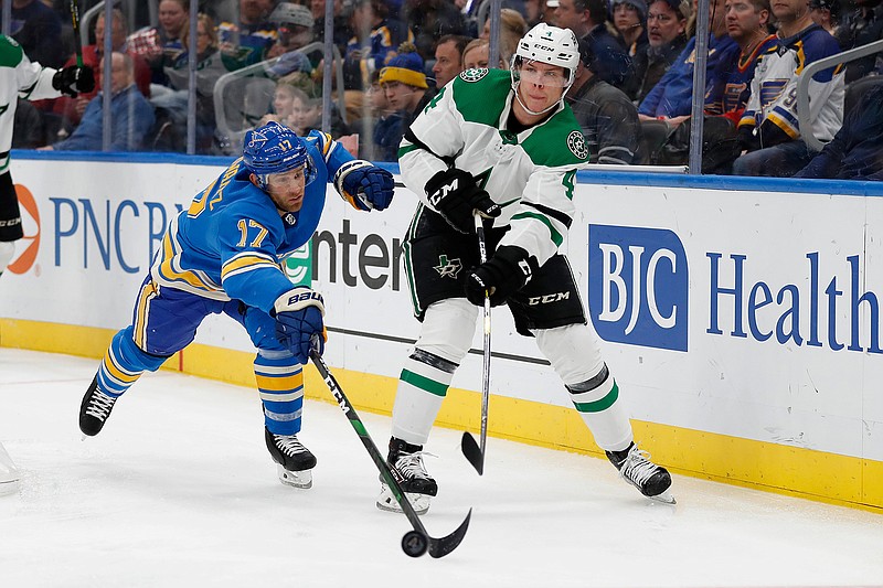 In this Feb. 8, 2020, file photo, Dallas Stars' Miro Heiskanen (4), of Finland, passes around St. Louis Blues' Jaden Schwartz (17) during the second period of an NHL hockey game in St. Louis. This is a Stanley Cup matchup for all of those who like their games to be a bit defensive. The Stars and the Tampa Bay Lightning, two of the league's southernmost teams playing for the title in a bubble at the NHL's most northern arena in Edmonton, both have defensemen who provide plenty of points. (AP Photo/Jeff Roberson, File)