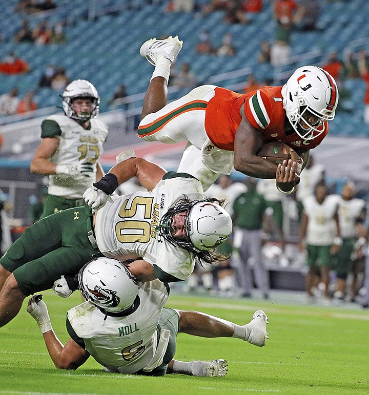 Miami quarterback D'Eriq King (1) leaps for a second-quarter touchdown against UAB during an NCAA college football game in Miami Gardens, Fla., Thursday, Sept. 10, 2020. (Al Diaz/Miami Herald via AP)