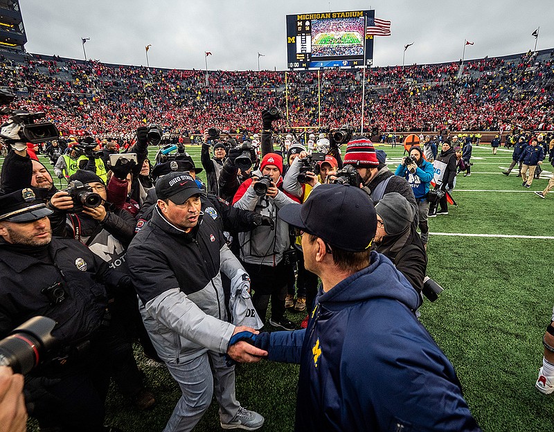 In this Nov. 30, 2019, file photo, Ohio State head coach Ryan Day, front left, shakes hands with Michigan head coach Jim Harbaugh, front right, after an NCAA college football game in Ann Arbor, Mich. The Big Ten's third football schedule of the 2020 season is highlighted by Michigan-Ohio State on Dec. 12, the final day of the conference's regular-season and the latest date the rivals have ever played. (AP Photo/Tony Ding, File)