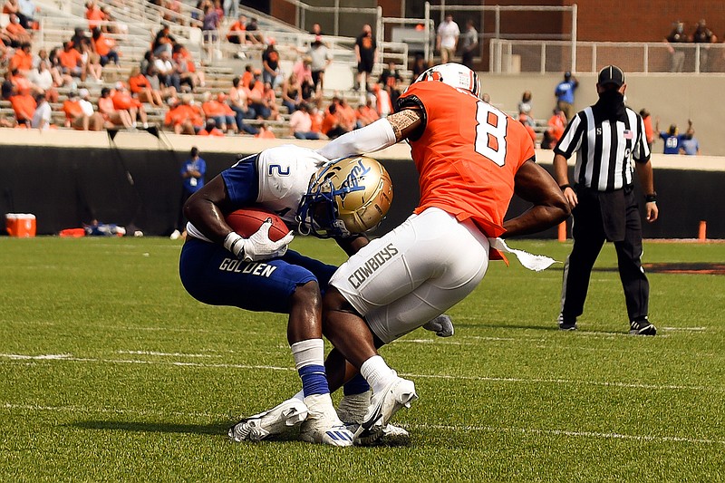 Tulsa running back Shamari Brooks (2) is stopped by Oklahoma State corner back Rodarius Williams (8) in the second half of an NCAA college football game Saturday, Sept. 19, 2020, in Stillwater, Okla. (AP Photo/Brody Schmidt)