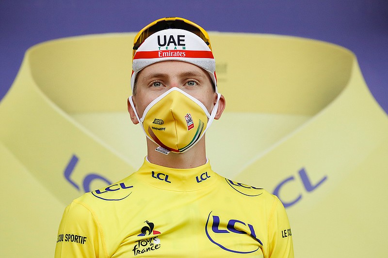 Stage winner and new overall leader, best young rider and best climber, Slovenia's Tadej Pogacar, wearing the yellow jersey, celebrates on the podium after stage 20 of the Tour de France cycling race, an individual time trial over 36.2 kilometers (22.5 miles), from Lure to La Planche des Belles Filles, France, Saturday, Sept. 19, 2020. (Sebastien Nogier/Pool via AP)