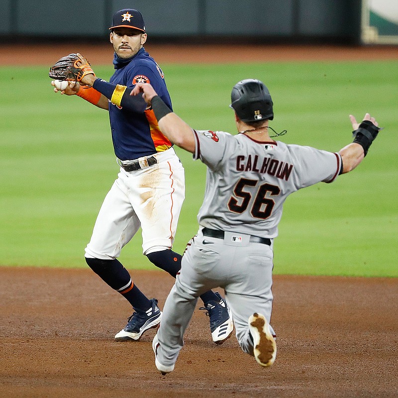 Houston Astros shortstop Carlos Correa turns a double play on the Arizona Diamondbacks' Eduardo Escobar after forcing out Kole Calhoun in the top of the fourth inning on Sunday, Sept. 20, 2020, in Houston. (Kevin M. Cox/The Galveston County Daily News via AP)