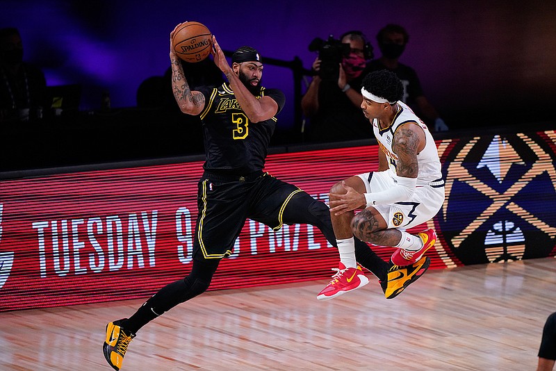 Los Angeles Lakers' Anthony Davis (3) saves a ball from going out of bounds in front of Denver Nuggets' Gary Harris, right, during the first half of an NBA conference final playoff basketball game Sunday, Sept. 20, 2020, in Lake Buena Vista, Fla. (AP Photo/Mark J. Terrill)