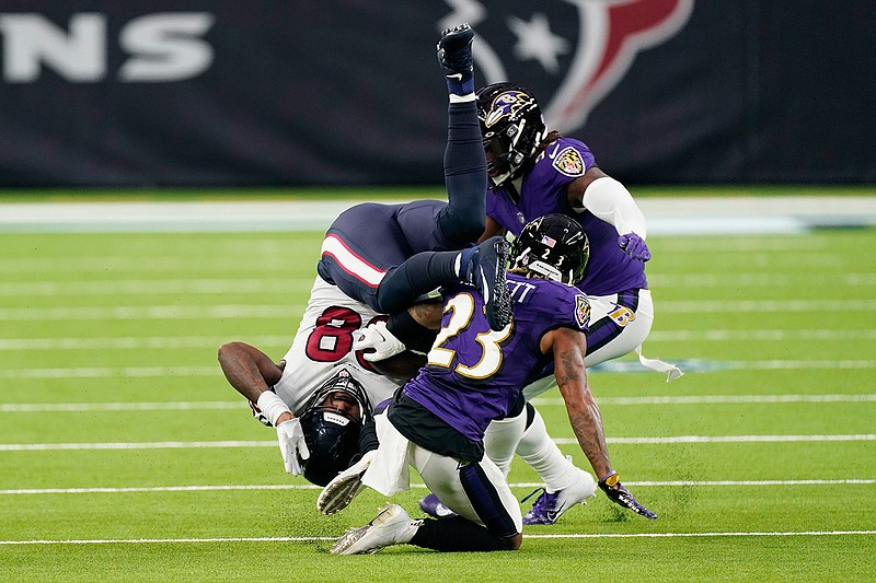 Houston Texans tight end Jordan Akins (88) is upended by Baltimore Ravens cornerback Anthony Averett (23) after making a catch during the second half  Sunday in Houston.