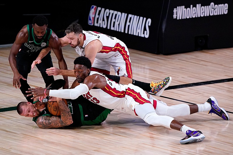 Boston Celtics' Kemba Walker, top left, and center Daniel Theis, bottom left, attempt to gain control of a loose ball against Miami Heat's Goran Dragic, top right, and forward Bam Adebayo, bottom right, during the second half of an NBA conference final playoff basketball game, Thursday, Sept. 17, 2020, in Lake Buena Vista, Fla. (AP Photo/Mark J. Terrill)