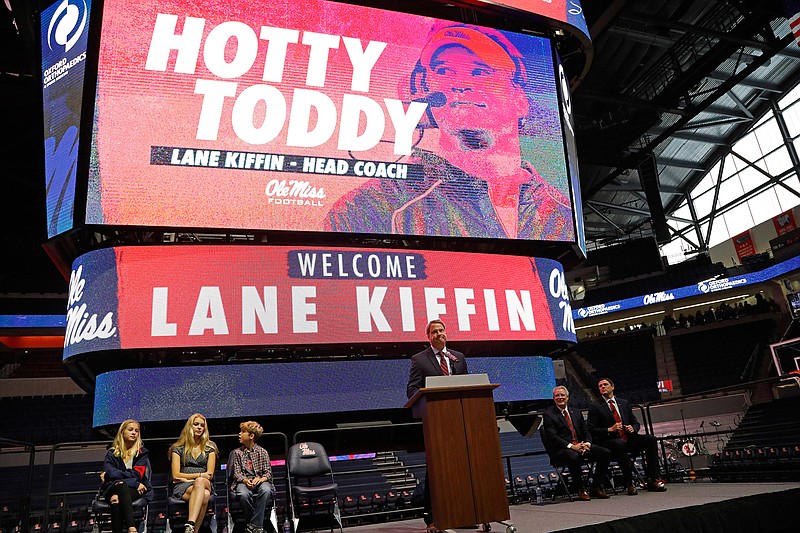 In this Monday, Dec. 9, 2019, file photo, Lane Kiffin speaks to Mississippi fans after being announced as the new head football coach during a introductory press conference in Oxford, Miss. In attendance were his children, daughters Presley Kiffin, 13, left, Landry Kiffin, 15, second from left, and son Knox Kiffin, 10. Mississippi State's Mike Leach and Mississippi's Lane Kiffin brought big names and offensive pedigrees to the Magnolia State. But they drew huge challenges for their debuts, with the Bulldogs visiting defending national champion and No. 6 LSU and the Rebels hosting No. 5 Florida. (AP Photo/Rogelio V. Solis, File)