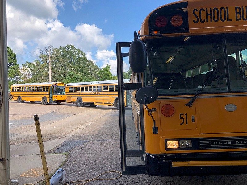 Hope Public Schools buses roll into the district's transportation facility for daily fogging to protect against COVID-19. Each bus in the 23-unit fleet is treated after both morning and afternoon routes. (Photo by Ken McLemore/Hope Public Schools)
