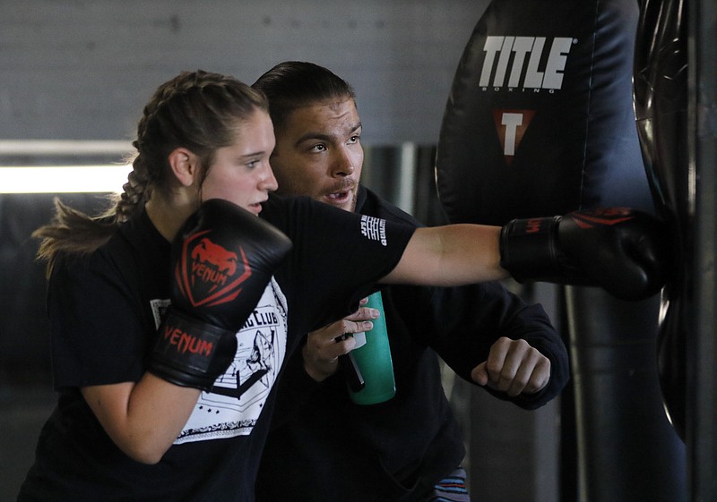 Liv Paggiarino/News Tribune

Mario Antonio helps Paige Sooter in her technique during a boxing session at ElmSt. Boxing Club. The just relocated to E. Capitol Ave., where Encore Department Store once was. Antonio credits the people who come and train with him as the people fueling the studio, saying it’s their drive and passion to come and work out that keep things going.