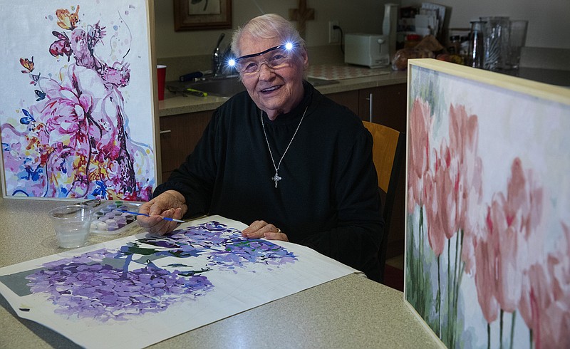 Terry Kriedeman, 89, looks up in her kitchen, where she works on a paint-by-number painting that her daughter started her on at the beginning of the pandemic. (Ellen M. Banner/The Seattle Times/TNS)