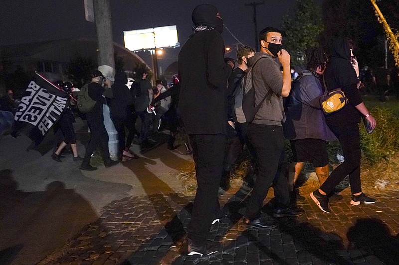 Protesters react to gunfire, Wednesday, Sept. 23, 2020, in Louisville, Ky. A police officer was shot in the evening. A grand jury has indicted one officer on criminal charges six months after Breonna Taylor was fatally shot by police in Kentucky. The jury presented its decision against fired officer Brett Hankison Wednesday to a judge in Louisville, where the shooting took place. (AP Photo/John Minchillo)