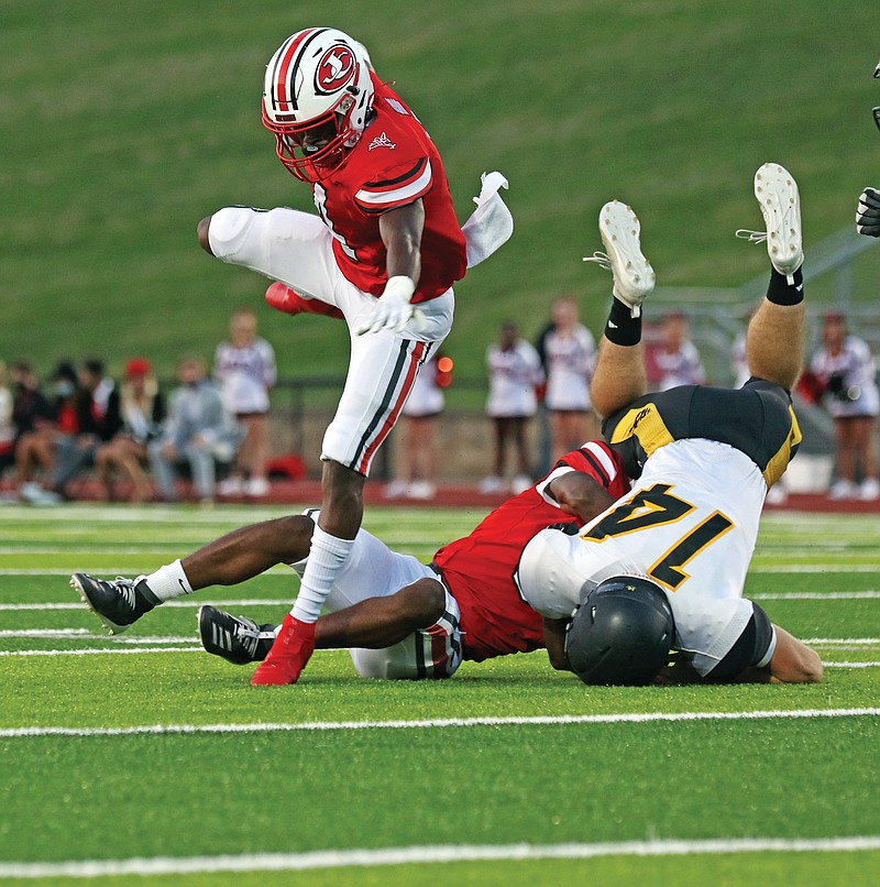 Jefferson City running back David Bethune jumps over a teammate and a defender during last Friday night's game against Sedalia Smith-Cotton at Adkins Stadium.