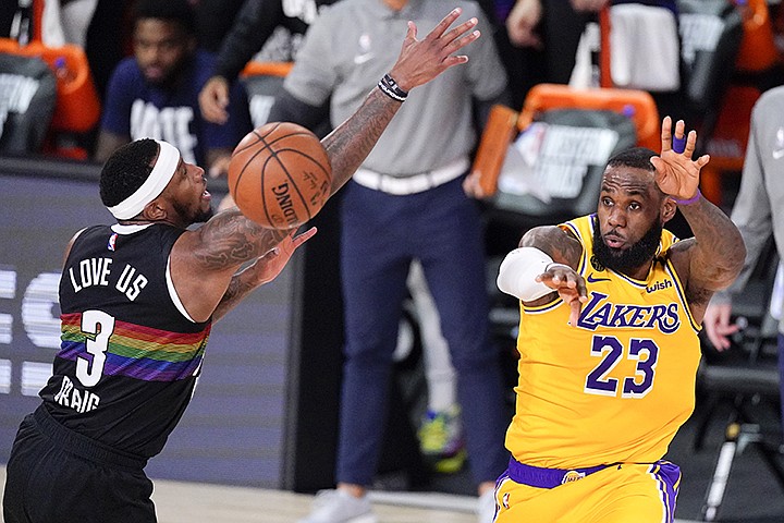 Los Angeles Lakers' LeBron James (23) passes the ball past Denver Nuggets' Torrey Craig (3) during the second half of an NBA conference final playoff basketball game Thursday, Sept. 24, 2020, in Lake Buena Vista, Fla. (AP Photo/Mark J. Terrill)