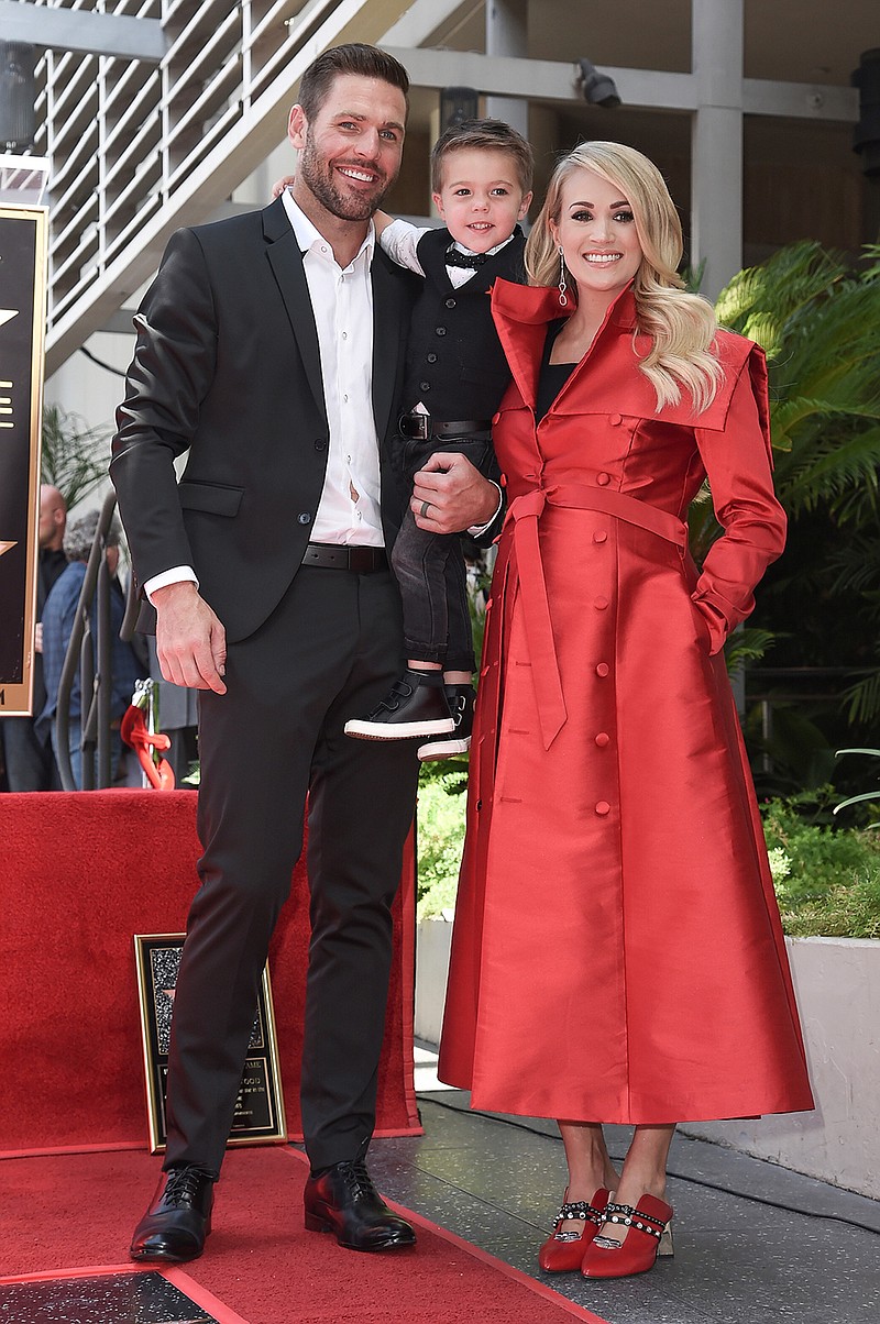 In this Sept. 20, 2018 file photo, singer Carrie Underwood poses with her husband Mike Fisher, and their son Isaiah Michael Fisher as they attend a ceremony honoring Underwood with a star on the Hollywood Walk of Fame, in Los Angeles.  Underwood's son provided the adorable vocals on "Little Drummer Boy," one of the 11 tracks on the country superstar's new Christmas album, "My Gift," out Friday, Sept. 25, 2020.  (Photo by Richard Shotwell/Invision/AP, File)