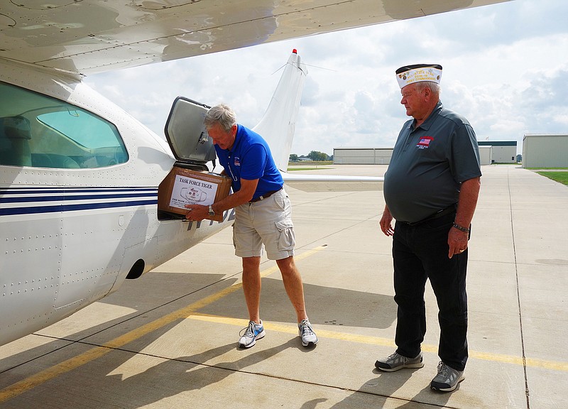 Steve Wendling, left, pulls the first of six boxes from his cargo hold to hand to George Laprade of the Chillicothe VFW. 