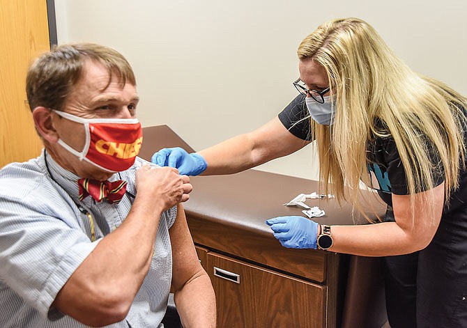 Cole County Health Department's Tara Fergerson administers a flu shot Friday to Dr. Randall Williams, director of the Missouri Department of Health and Senior Services.