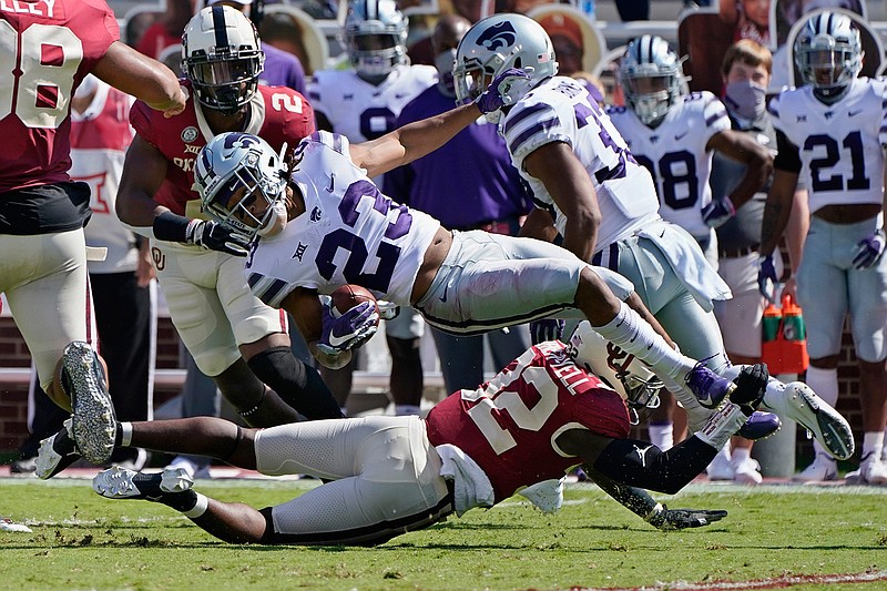 Kansas State wide receiver Joshua Youngblood (23) is upended by Oklahoma defensive back Delarrin Turner-Yell (32) in the first half of an NCAA college football game Saturday, Sept. 26, 2020, in Norman, Okla. (AP Photo/Sue Ogrocki).
