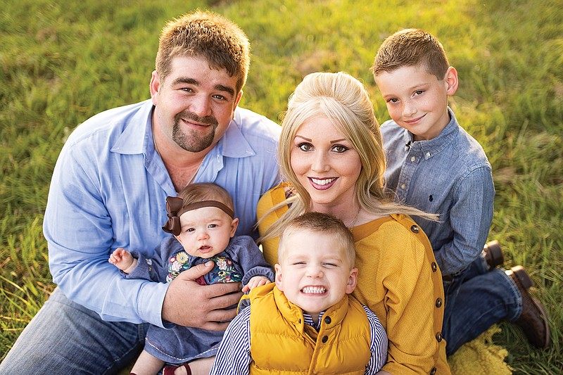 Braden and Kimberly McDaniel sit with their children, Cannon, Connor and Collyns.