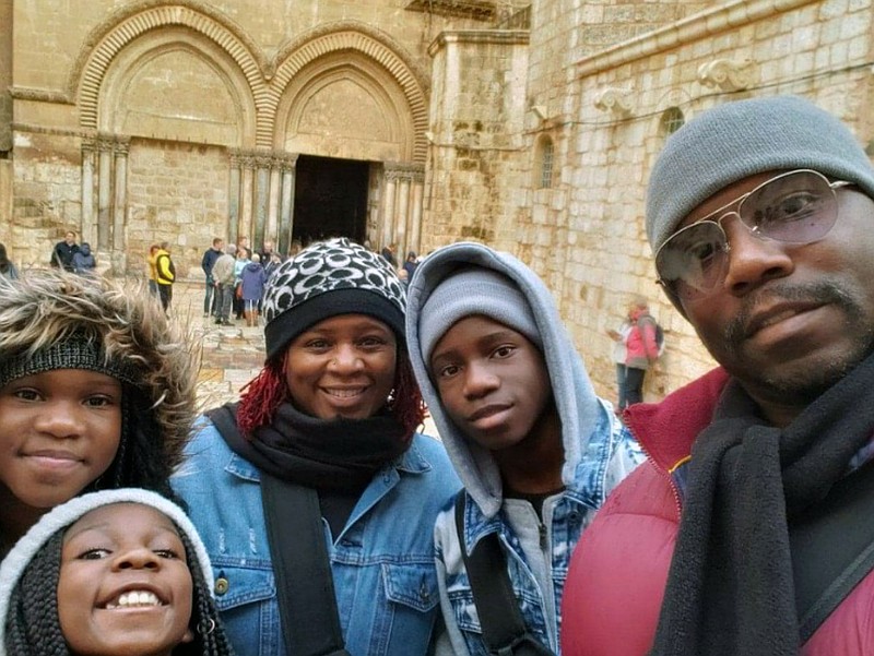 This photo shows the Brown family of Atlanta, from left, Jayde Brown, Jay’Elle Brown, Jayson R. Brown, Tammy Brown and Jayson E. Brown at the Church of the Holy Sepulchre in Jerusalem on Dec. 27, 2019.  Parents Tammy and Jayson have been taking their kids on educational trips for five years and are among families heading out with remote-learning kids during the new school year rather than leaving them stuck at home. (Jayson E. Brown via AP).
