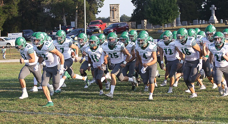 Blair Oaks seniors Nico Canale (57) and Carson Prenger (13) lead the Falcons onto the field before last Friday's game against Valle Catholic at Fr. John Dempsey Field in Ste. Genevieve.