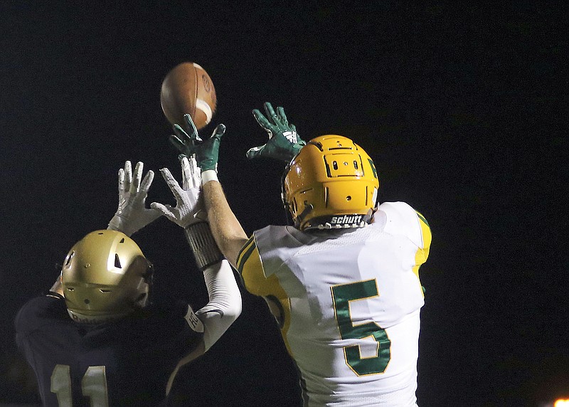 Helias defensive back Drew Higgins bats away a pass intended for Rock Bridge wide receiver Payton Messer during last Friday night's game at Ray Hentges Stadium.