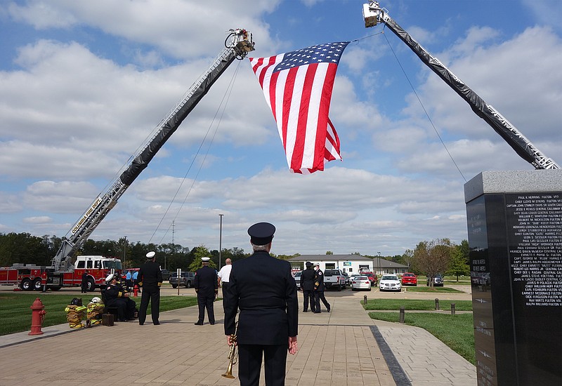 <p>Helen Wilbers/For the News Tribune</p><p>A bugler watches as a giant American flag ascends before the annual memorial service Friday at the Missouri Fire Fighters Memorial, located in Kingdom City. Three firefighters were commemorated Friday for their deaths in the line of Duty.</p>