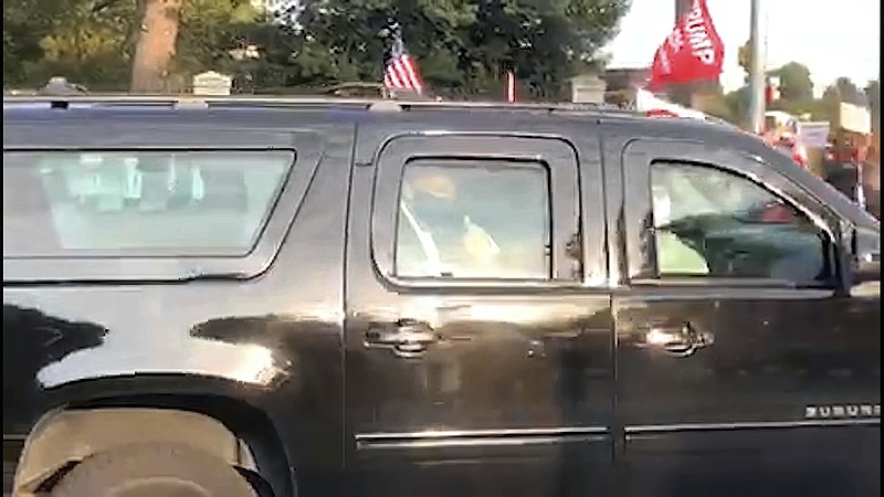 In this image from video, President Donald Trump drives past supporters gathered outside Walter Reed National Military Medical Center in Bethesda, Md., Sunday, Oct. 4, 2020. Trump was admitted to the hospital after contracting COVID-19. (AP Photo/Phillip Crowther)