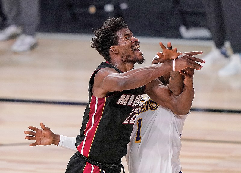 Jimmy Butler of the Heat is fouled by Kentavious Caldwell-Pope of the Lakers during Sunday night's Game 3 of the NBA Finals in Lake Buena Vista, Fla.