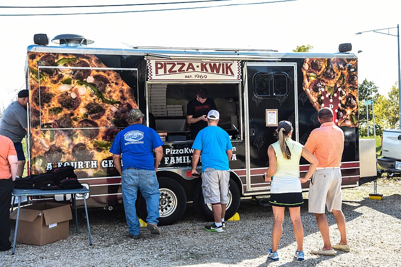 Julie Smith/News TribuneThe new Pizza Kwik food truck made its debut Friday. The owners parked at the corner of Tanner Bridge and Ellis on the parking lot of Knights of Columbus and had a steady line of customers.