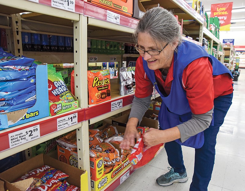 Becky Timberlake straightens items in the candy aisle at Save a Lot on Jefferson City's east side. The store has stocked large bags of candy for Halloween in hopes that despite COVID-19, children will still be able to go trick-or-treating.