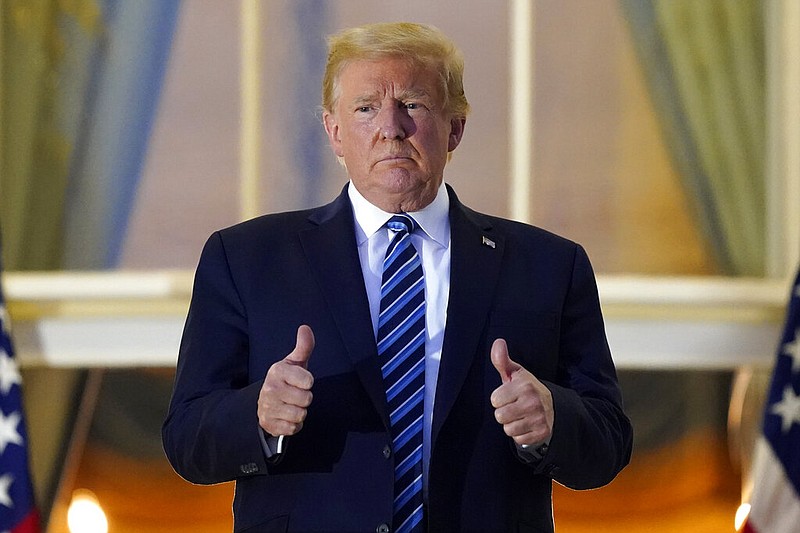 President Donald Trump stands on the balcony outside of the Blue Room as returns to the White House Monday, Oct. 5, 2020, in Washington, after leaving Walter Reed National Military Medical Center, in Bethesda, Md. Trump announced he tested positive for COVID-19 on Oct. 2. (AP Photo/Alex Brandon)