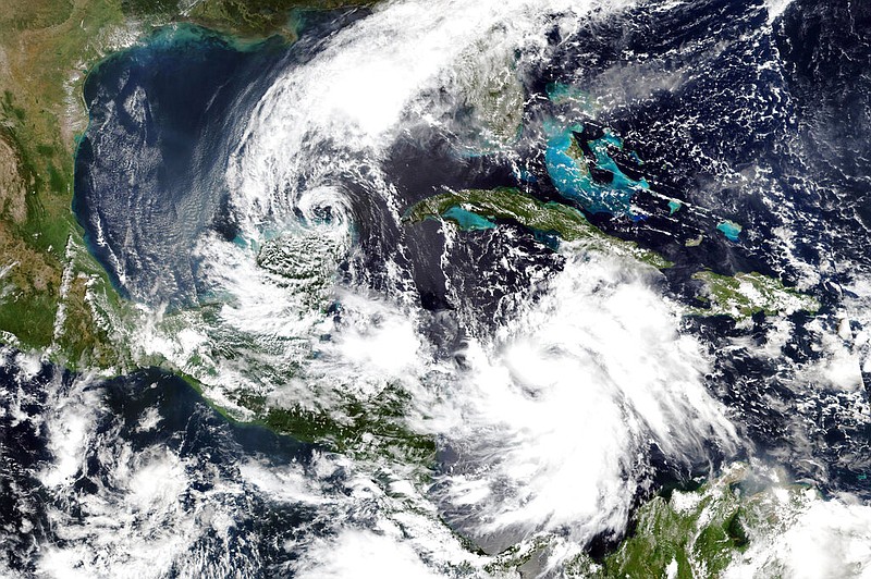 This Monday, Oct. 5, 2020, satellite image released by NASA Worldview, Earth Observing System Data and Information System (EOSDIS) shows Tropical Storm Gamma, left, which soaked part of Mexico over the weekend and a strengthening Hurricane Delta, lower right, which is on a course to pass by the Cayman Islands early Tuesday. (NASA via AP)