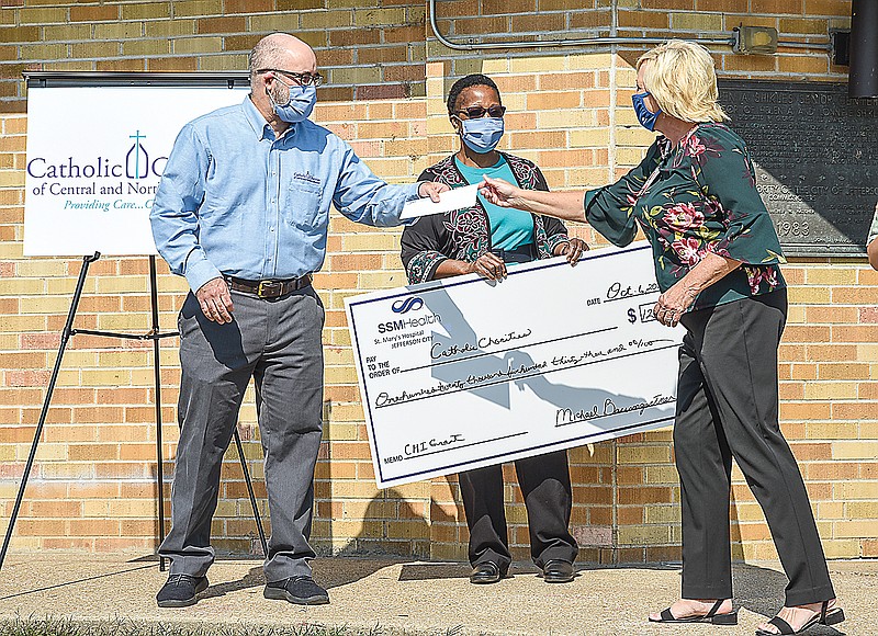 Bev Stafford, executive director of SSM Health St. Mary's Hospital Foundation, at right, was at Shikles Center on Tuesday to present a check to Dan Lester, executive director of Catholic Charities of Central and Northern Missouri, who accepted it on behalf of the organization. Also pictured is Judith Mutamba, Catholic Charities director of Health and Nutrition Program.