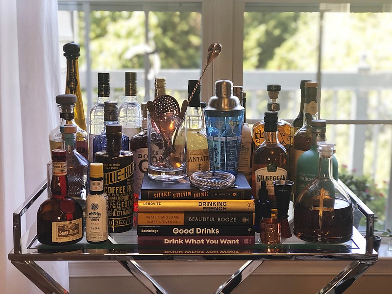 A collection of spirits and cocktail recipe books are displayed at a home in Alexandria, Va., on Oct. 4, 2020. Since the pandemic hit the United States, a lot of social drinking has moved back home. (Elizabeth Karmel via AP)